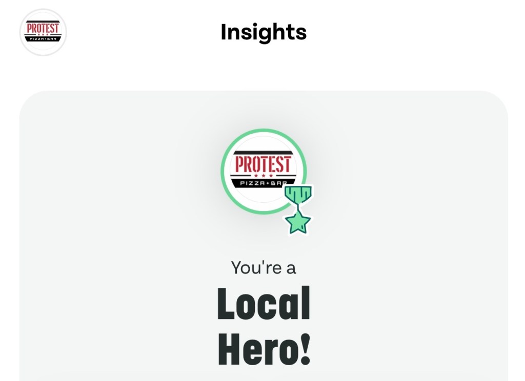 Badge from Protest Pizza Bar displaying 'You're a Local Hero!'